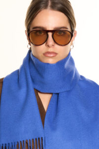 A navy cashmere scarf displayed in an elegant handcrafted box.