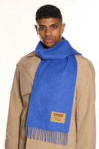 A navy plaid cashmere scarf in a luxury handcrafted gift box.