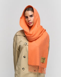 A high-fashion editorial shot of a red tartan cashmere scarf.