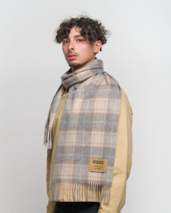 An elegant lifestyle shot of a woman in Shanghai wearing a classic Scottish check scarf, blending Eastern and Western aesthetics.